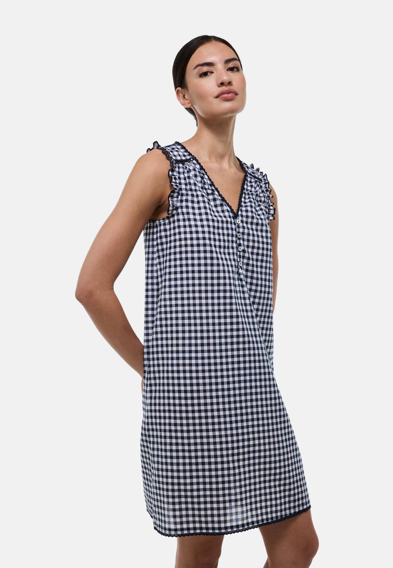 Robe sans manches à carreaux bleus et blancs avec des bretelles à volants, un décolleté en V et des détails de boutons, se terminant juste au-dessus du genou.