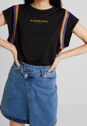Sort bomulds t-shirt med korte ærmer, med flerfarvede stribeaccents og "G-STAR RAW" logo, kombineret med et denimskørt.