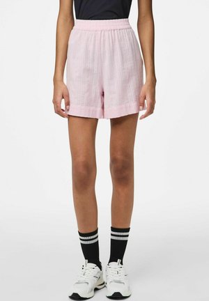 Lys pink shorts med elastisk talje, i en struktureret stof og lige pasform, parret med hvide sneakers og sorte stribede sokker.