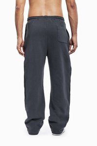 Mørkegrå sweatpants med løs pasform, elastisk talje, og en baglomme, lavet af et blødt, tekstureret stof.