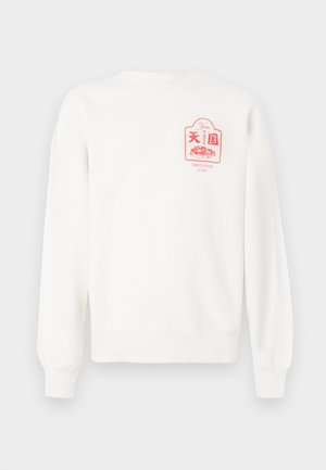 Fehér pulóver hosszú ujjakkal, bordás mandzsettával és aljjal. Bal mellkas területén rózsaszín grafikus mintázat található, amely ételt és szöveget ábrázol.