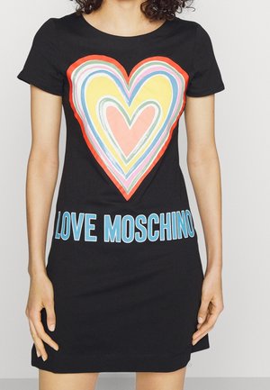 Czarna sukienka z krótkim rękawem z dużą, kolorową grafiką serca i niebieskim napisem "LOVE MOSCHINO" u dołu. Wykonana z bawełny, dopasowany krój.