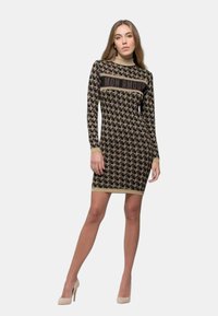 Abito lavorato a maglia nero con un motivo di uccelli beige, scollatura alta, maniche lunghe e la scritta "MON AMOUR" sul petto in caratteri scuri.