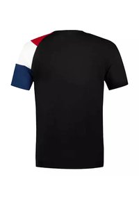 Zwarte T-shirt met korte mouwen met contrasterende rode, witte en blauwe accenten op de linkerschouder. Soepele textuur, ronde halsontwerp.