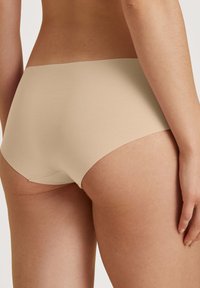 Beige katoenen hipster slipjes met een gladde textuur, voorzien van een naadloos ontwerp en een medium hoge taille voor een comfortabele pasvorm.