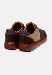 Braune und beige Sneakers aus Wildleder und Textilmaterialien, mit runder Form, kontrastierenden Farbpaneelen und einer robusten Gummisohle.