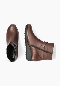 Bottines en cuir marron avec une semelle épaisse noire, fermeture éclair sur le côté et accents texturés sur le dessus. Fini lisse, design à bout rond.