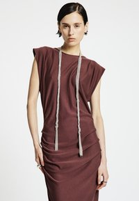 Robe drapée couleur bordeaux avec larges épaules et silhouette ajustée. Présente des détails en corde grise, une texture lisse et un design subtilement froncé.