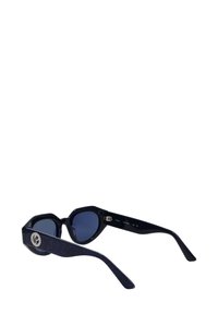 Kuusnurkse kujuga päikeseprillid tumesiniste läätsedega, mustade läikivate raamidega ja tekstureeritud tumesiniste varrega, millel on ringikujuline logo detail.