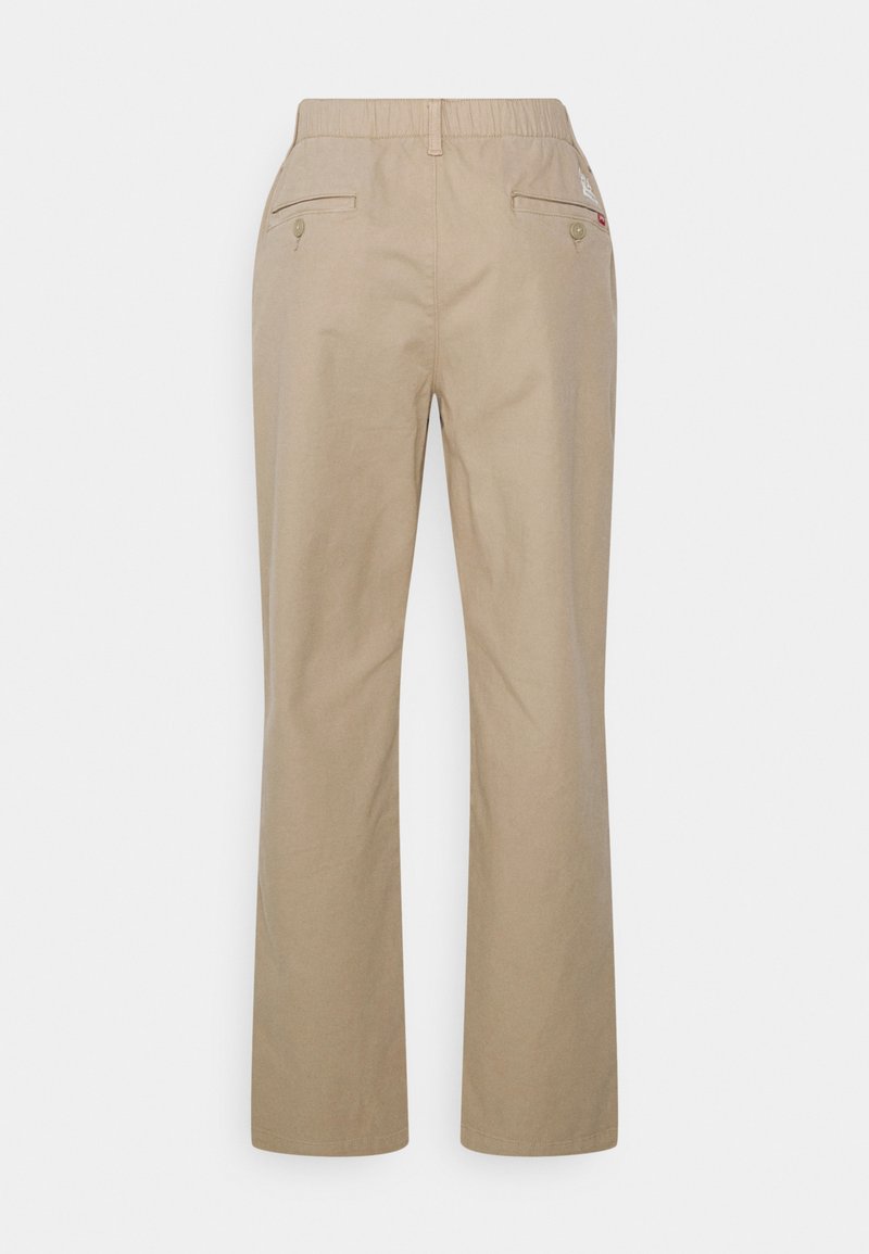 Pantalons en coton beige avec une coupe décontractée, dotés d'une taille extensible, de deux poches arrière et de détails de couture subtils.