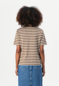 Brun og hvit stripete T-skjorte med rund hals og korte ermer, laget av mykt stoff. Brukt med en denimskjørt.
