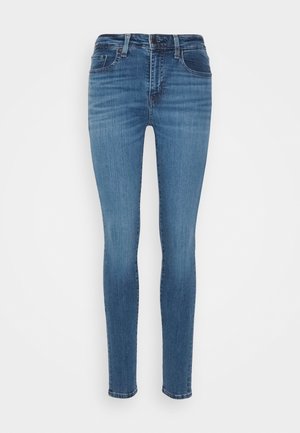 Slanke jeans i mid-blå denim, med høj talje, et klassisk fem-lomme design og subtile whiskering-effekter på stoffet.