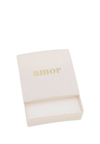 Liten vit fyrkantig ask med guldtexten "amor" på locket, som är något öppet och visar ett mjukt vitt inre.