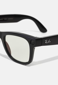 Lunettes intelligentes Ray-Ban noires de forme rectangulaire avec des caméras intégrées aux coins avant et des verres légèrement teintés.