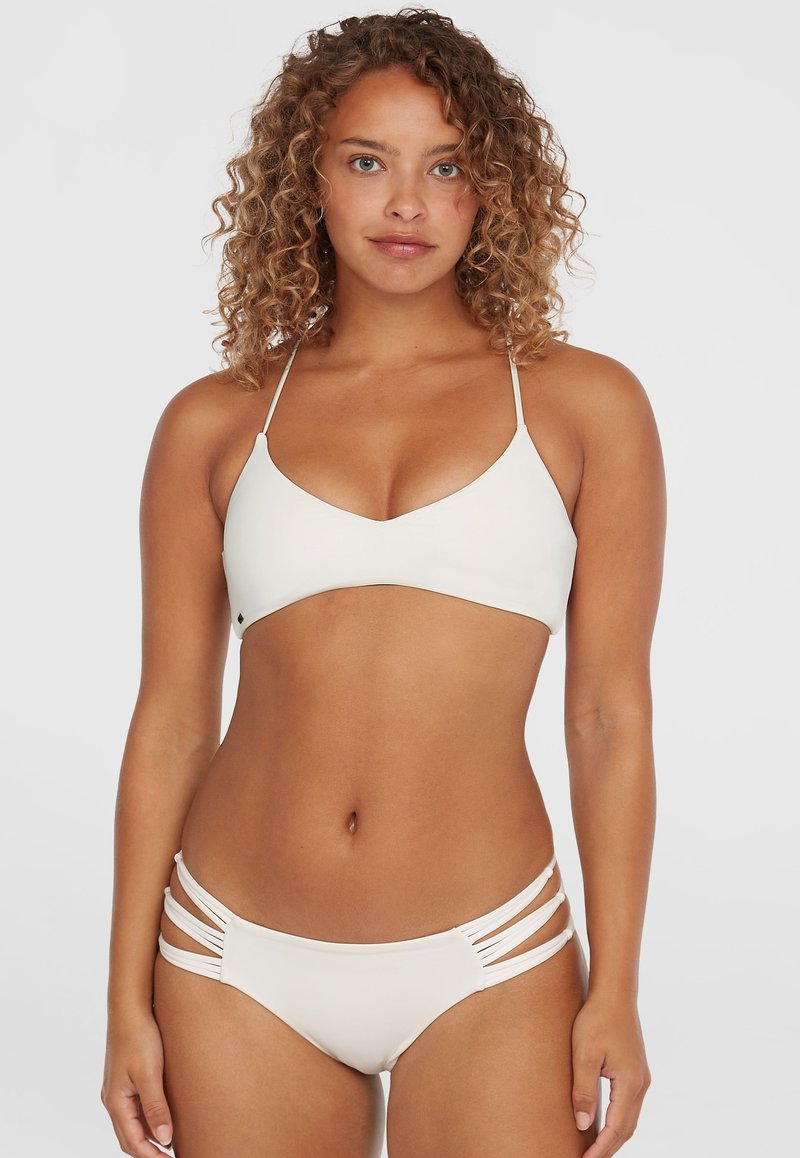 Biały zestaw bikini z trójkątnym stanikiem z cienkimi ramiączkami oraz dołami z niskim stanem i wycięciami po bokach. Gładka tekstura, minimalistyczny design.