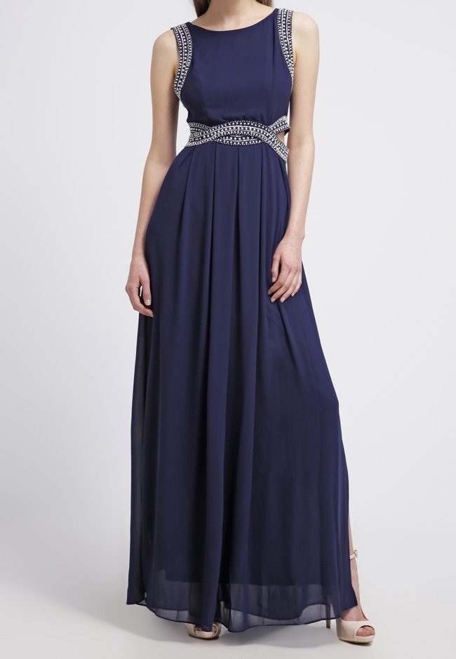 Navy-blaues ärmelloses Abendkleid mit silbernen Perlendetails an den Trägern und der Taille, getragen mit beigen High Heels.
