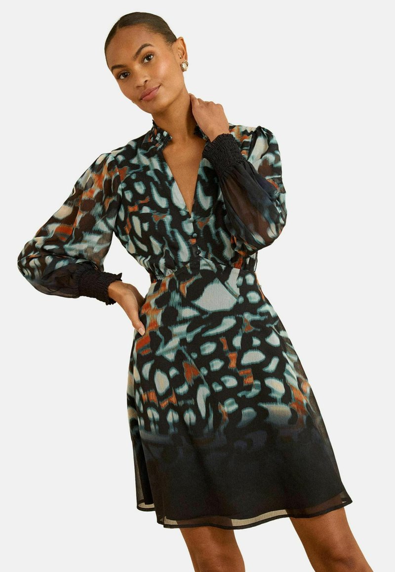 Rochie din material ușor, cu un imprimeu floral pe un fond negru, având mâneci bufante, un decolteu adânc în V și elastic smockat la manșete.