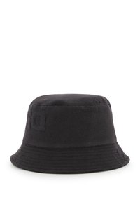 Chapeau seau en coton noir avec surface texturée, sommet légèrement arrondi et large bord plat. Présente un détail de logo en relief sur le côté.