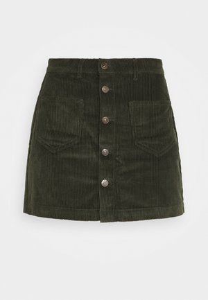 Mini-jupe en velours côtelé vert foncé avec cinq boutons à l'avant et deux poches avant, présentée sur un fond blanc.