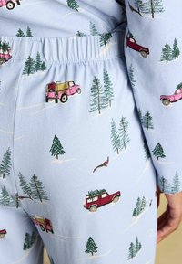 Svetlomodré pyžamové nohavice s hravým motívom ružových a červených áut, vždyzelených stromov a vtáka. Viditeľný elastický pás.