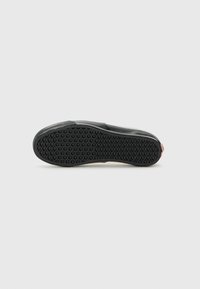 Black sneaker sole with a textured rubber surface featuring a diamond pattern for grip, smooth upper part, and a pink accent at the heel.