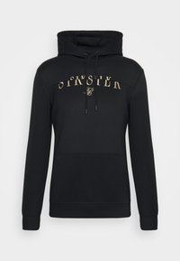 Sudadera negra de manga larga con bolsillo frontal tipo pouch, capucha con cordón y texto de logo arqueado beige junto con un emblema en el pecho.