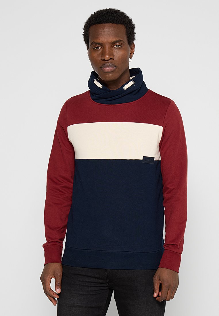 Heren sweatshirt in rood, marineblauw en roomkleur. Heeft een funnelnek, horizontale kleurblokken en een klein logo op de voorkant. Gemaakt van een katoenmix.