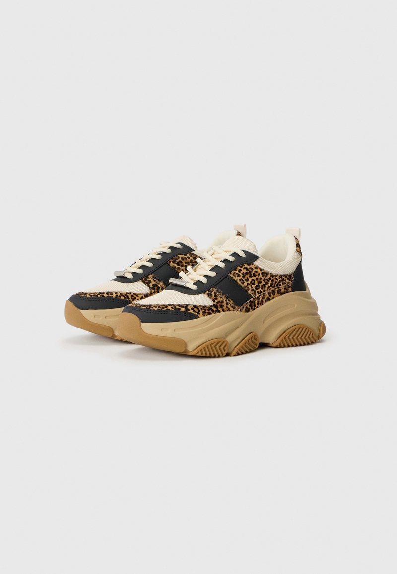 Sneakers chunky con una toma nera e stampa leopardata, dettagli crema e suola in gomma beige, dotate di lacci spessi e finitura testurizzata.