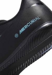 Scarpa da calcio sintetica nera con superficie testurizzata, caratterizzata da un marchio "MERCURIAL" azzurro chiaro e una suola in gomma con un motivo distintivo.