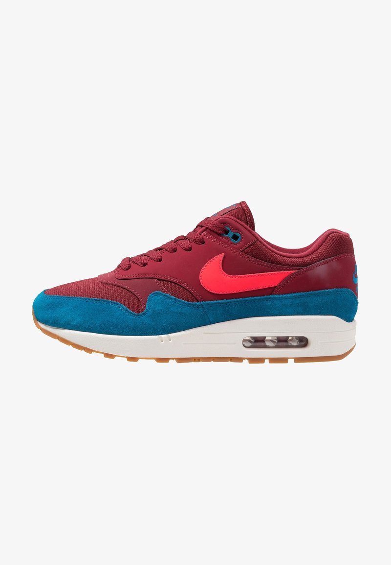 Nike Air Max sneaker with a maroon upper, blue suede accents, a pink logo, and a white midsole, featuring visible air cushioning and a gum sole.