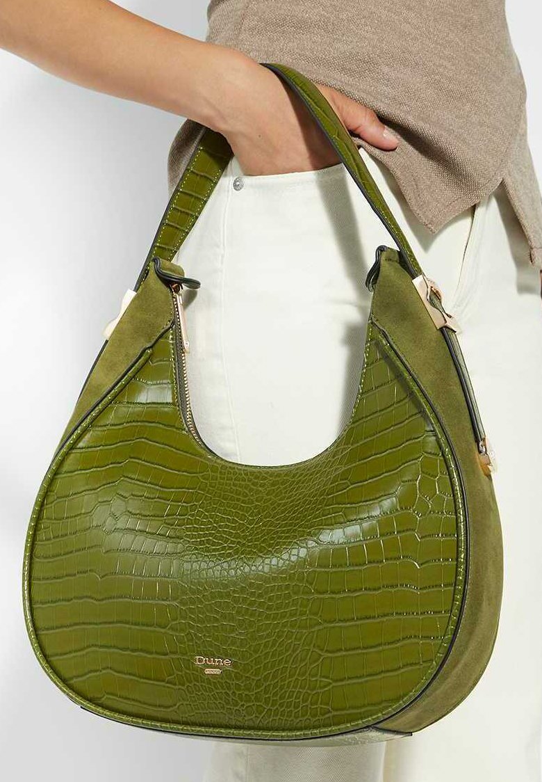 Green faux leather handbag featuring a crocodile texture, soft suede accents, a curved shape, and a zippered closure. Brand logo displayed.