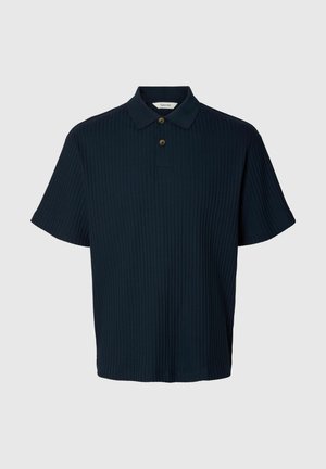Polo bleu marine foncé à manches courtes avec une texture côtelée verticale et deux boutons marron sur la patte de boutonnage.