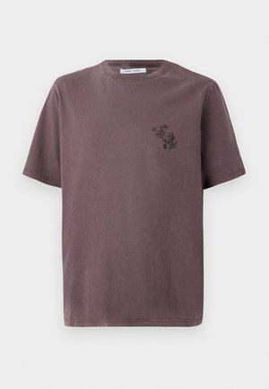 Camiseta de manga corta, de corte relajado, en un tono malva tenue, con un pequeño diseño gráfico negro en el lado izquierdo del pecho y un cuello redondo clásico.