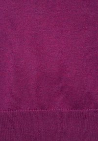 Lila Strickstoff mit glatter Textur, der ein feines Rippenmuster aufweist. Das Material wirkt weich und gleichmäßig gestrickt.