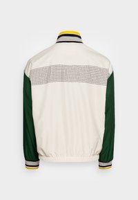 Bílá bunda se zelenými rukávy, s mřížkovým vzorem na horní části zad, pruhovaným límcem a elastickým pasem a manžetami.