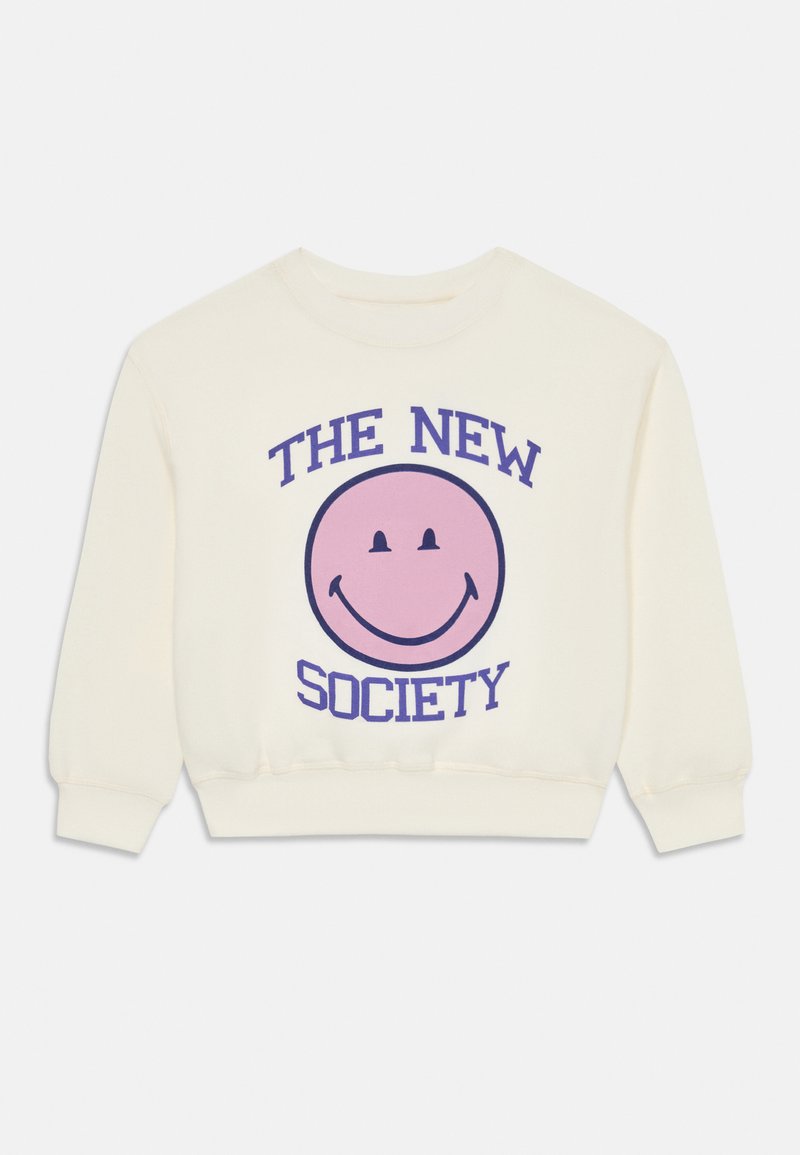 Κρέμα φούτερ με χαρακτηριστική μεγάλη ροζ χαμογελαστή φατσούλα και μπλε κείμενο που γράφει "Η ΝΕΑ ΚΟΙΝΩΝΙΑ" από πάνω και από κάτω. Μακριά μανίκια, ριμπ μανσέτες.