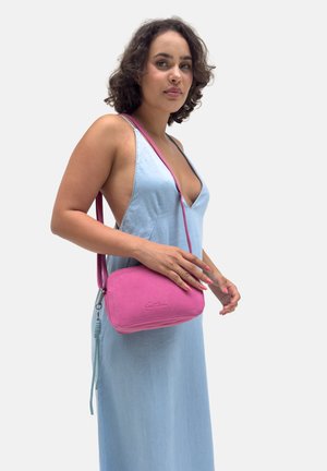 Rosa Wildleder-Crossbody-Tasche mit rechteckiger Form, strukturiertem Oberflächenmaterial und mit Quaste verziert. Trägt man mit einem verstellbaren Schulterriemen.