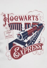 Hogwarts Express grafikk på hvitt stoff; viser et illustrert svart tog med røde og marine detaljer, samt vintage-stil tekst.