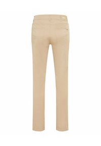 Beżowe spodnie o prostych nogawkach pokazane od tyłu, z dwoma kieszeniami, szlufkami na pasek i małą metką "Brax" na pasie.