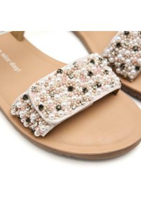 Sandalias planas con suela beige y una tira ancha adornada con cuentas rosas y blancas, gemas negras y acentos texturizados.