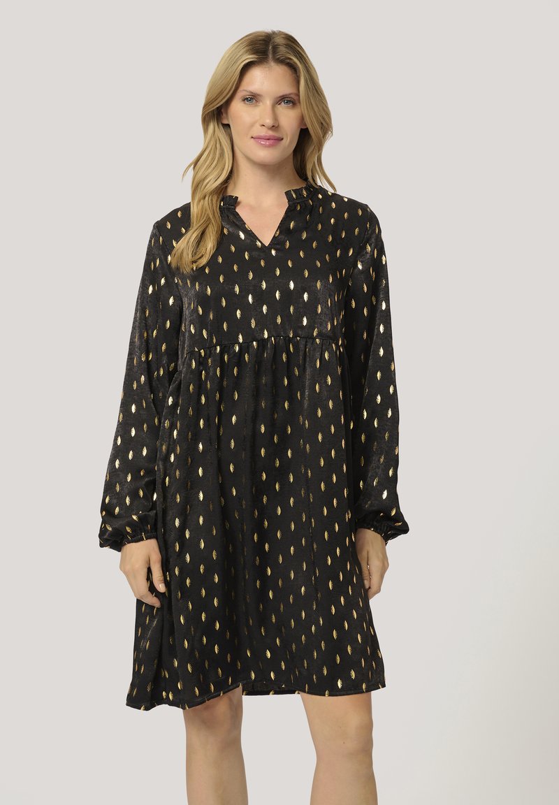 Robe noire avec un col en V et des manches longues. Présente un motif texturé de formes de feuilles d'or. Coupe ample, taille froncée, longueur à mi-cuisse.