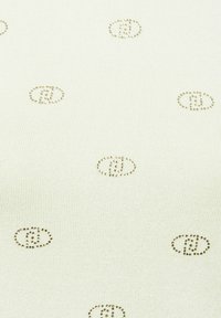 Textil de color verde claro con una sutil textura acanalada y pequeños patrones ovalados repetidos en un color dorado metálico.