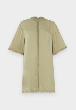 Oliivinvihreä lyhythihainen paita, jossa on pyöreä pääntie ja frilliyksityiskohtia edessä ja hihansuissa. Valmistettu pehmeästä kankaasta, rento istuvuus.