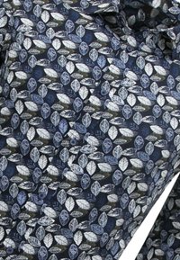 Marine stof met een bladerenpatroon in wit, lichtblauw en groen. Voorzien van knopen en een gestructureerde afwerking. Geschikt voor casual wear.