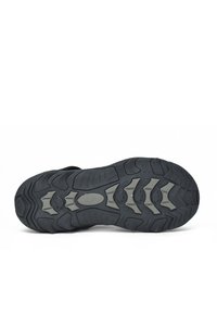 Suela de zapato de goma negra con acentos grises texturizados y profundas ranuras para un buen agarre. Presenta múltiples patrones curvados y angulares para mayor tracción.