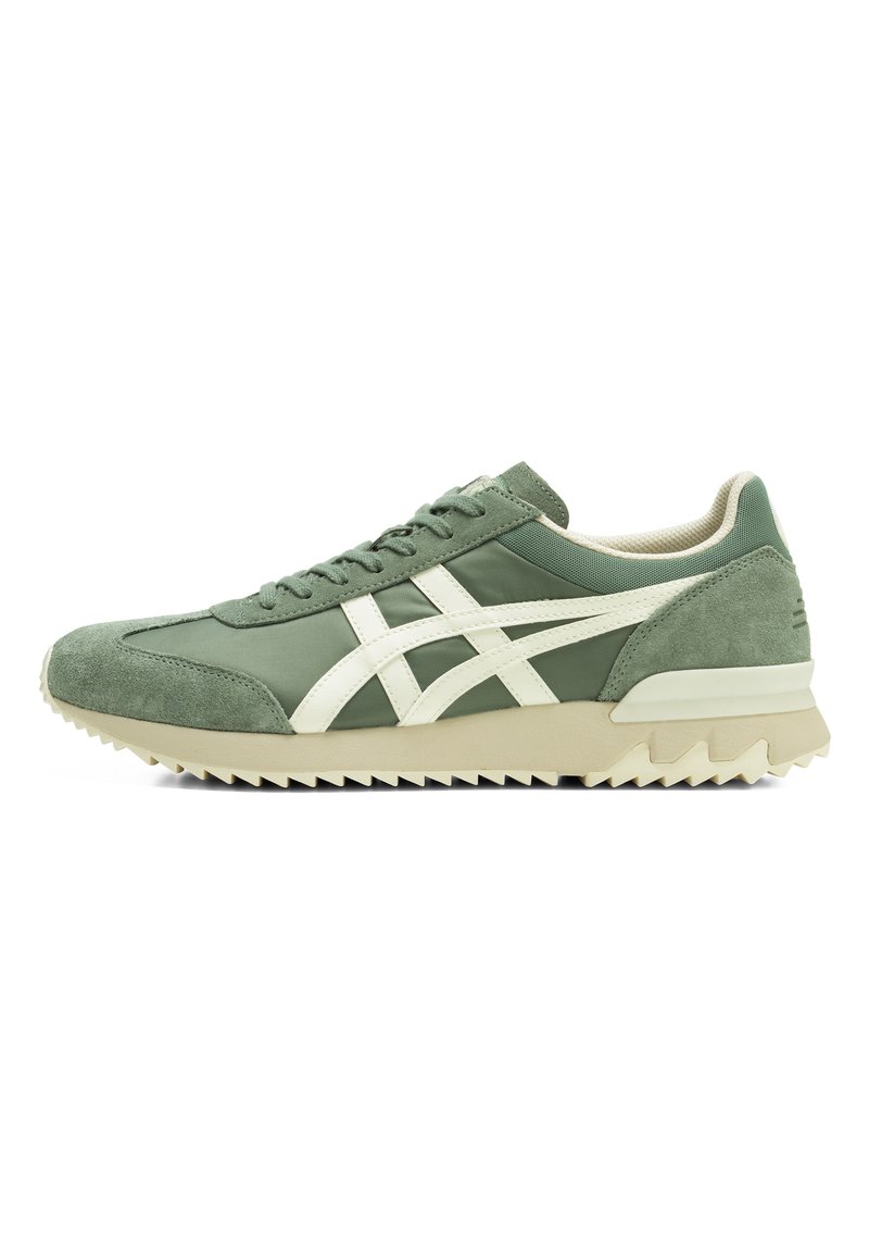 Green suede and fabric athletic shoe with white accents, featuring a textured sole and a streamlined design for comfort and stability.