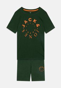 Ensemble en coton vert composé d'un t-shirt avec un logo en spirale orange et d'un short assorti, le tout avec une texture douce.
