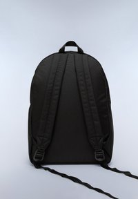 Zaino in tessuto nero con parte superiore arrotondata, spallacci regolabili e una piccola maniglia. Materiale testurizzato e design minimalista.