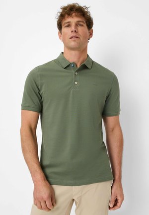 Olijfgroene polo met een kraag en korte mouwen. Heeft een blauwe knop aan de bovenkant en subtiele branding op de borst.
