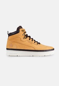 Sneaker alta in suede beige con accenti marroni, occhielli in metallo e suola in gomma bianca. Presenta un logo impresso di lato e un collo imbottito.